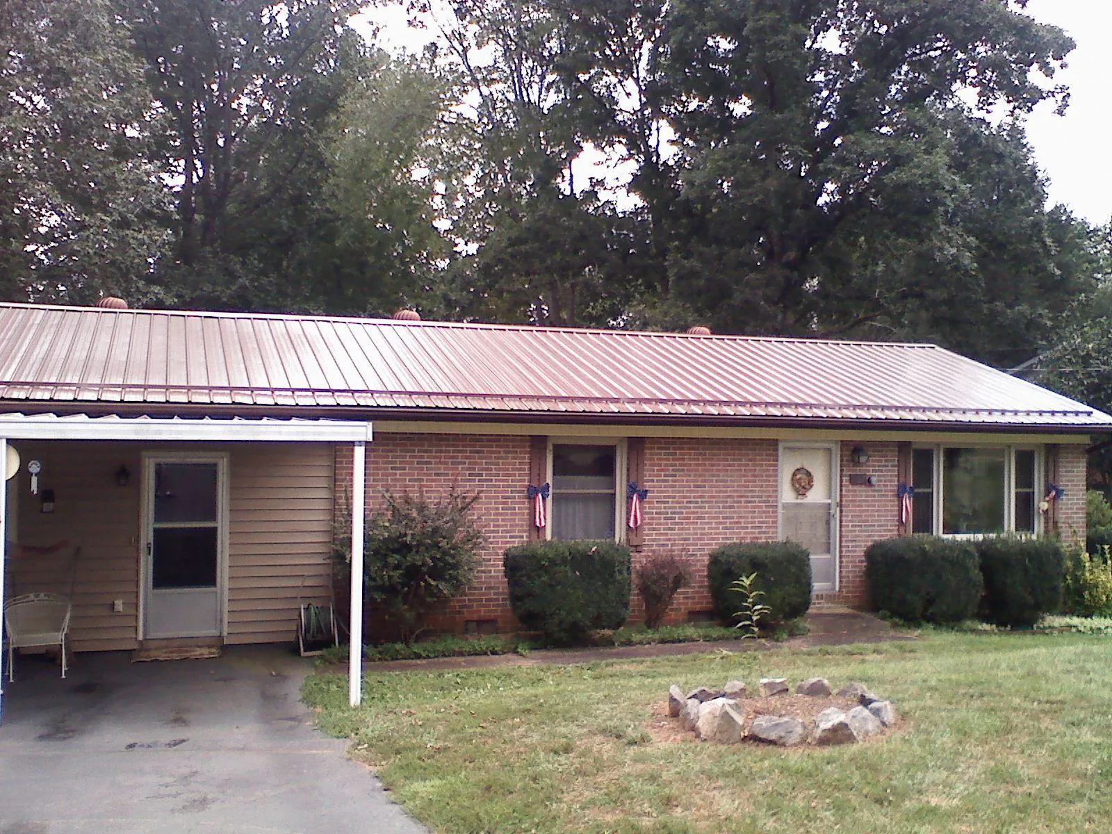 Bronze metal roof and carport on a brick ranch home — Roof Repair work by our crew in Romulus