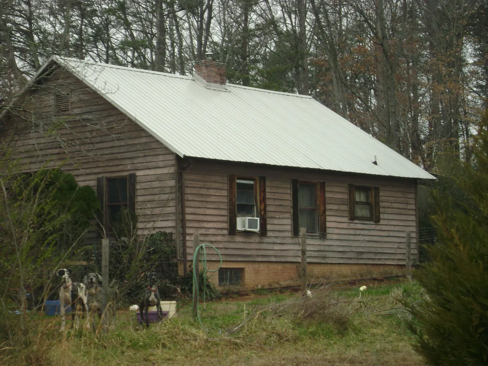 White metal roof on an old wood sided farmhouse, from a Metal Roof Installation job in Romulus